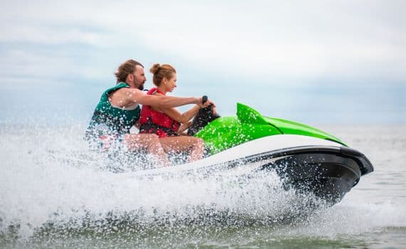 Couple enjoying a thrilling jet ski ride on vacation